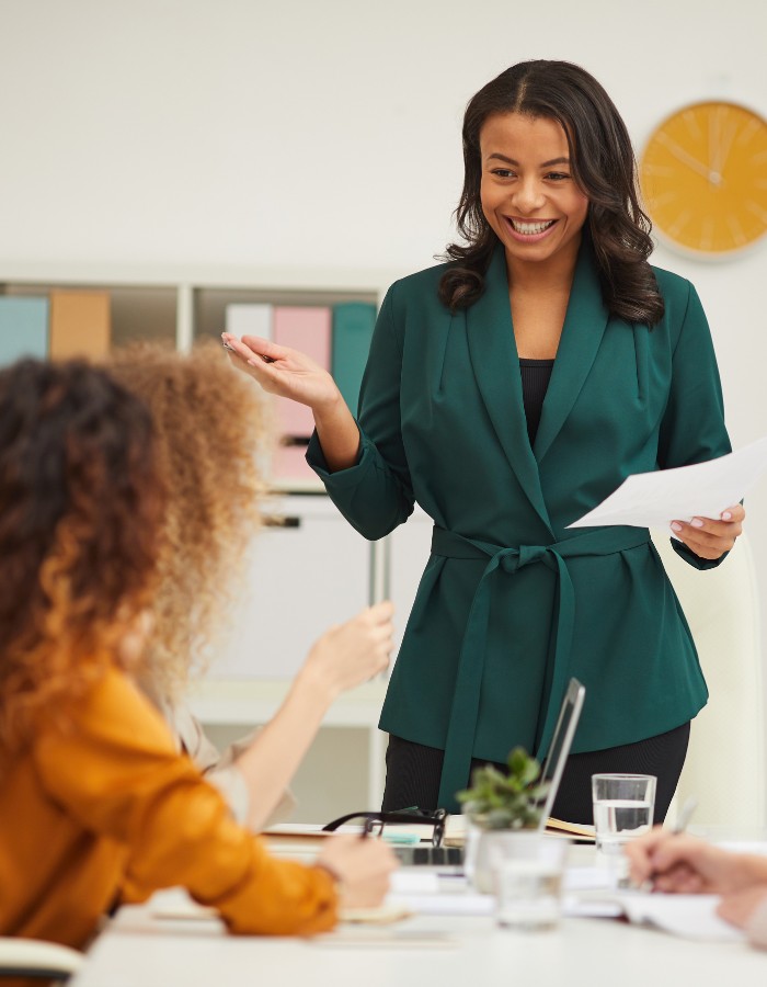 Woman in teal wrap-around jacket sharing financial information