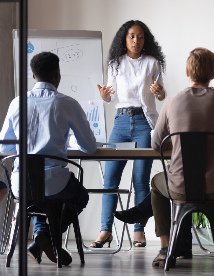 Black woman teaching small group of finance students