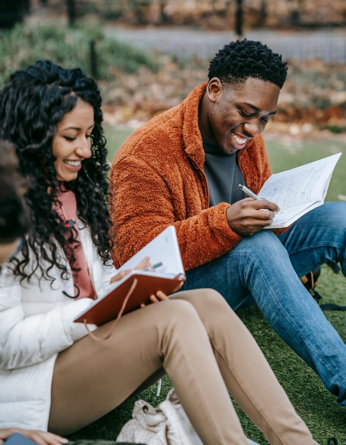 College friends laughing while studying in the courtyard