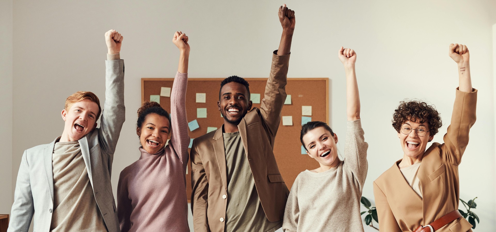 Group of business people celebrating with arms in the air