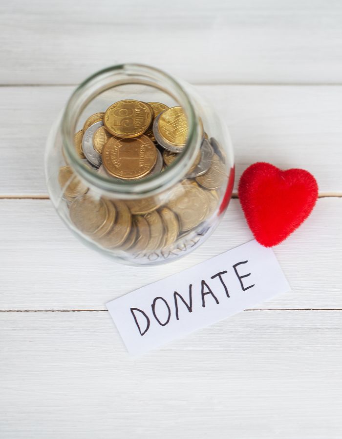 Jar of coins next to heart and donate tag
