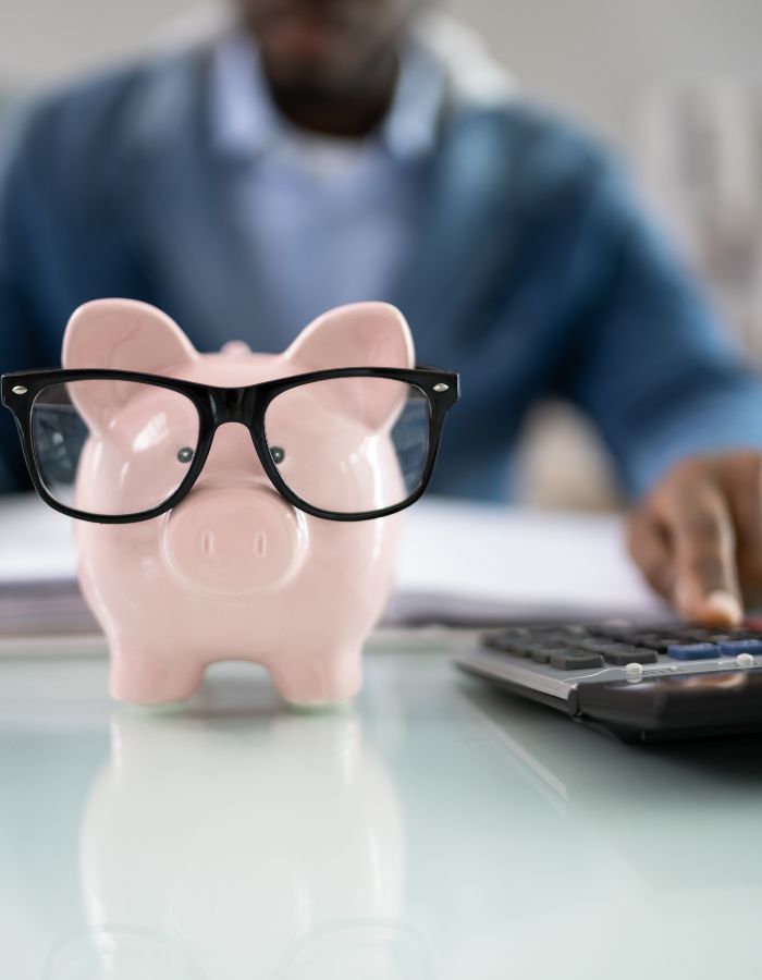 Pink piggy bank wearing black-framed glasses